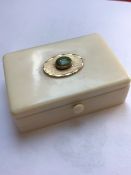 A SMALL ANTIQUE IVORY TRINKET BOX WITH HINGED LID CENTERED WITH YELLOW METAL AND GREEN CABUCHON