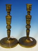 A PAIR OF ANTIQUE FRENCH BRASS EMPIRE STYLE CANDLESTICKS, ENGRAVED DECORATION. H. 26cms.