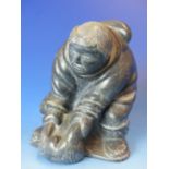 AN INUIT CARVED LIMESTONE FIGURE OF A HUNTER, BASE INSCRIBED. H. 16cms.
