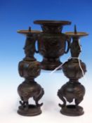 A JAPANESE BRONZE PRICKET CANDLESTICK GARNITURE, EACH PIECE WITH MASK AND TONGUE HANDLES AND CAST