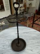 A CAST IRON STICK STAND, A RING HANDLE ABOVE SNAKES FORMING CIRCLES ABOVE THE CLUSTER COLUMN AND