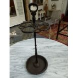 A CAST IRON STICK STAND, A RING HANDLE ABOVE SNAKES FORMING CIRCLES ABOVE THE CLUSTER COLUMN AND