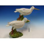 A PAIR OF MAJOLICA WHITE WADING BIRDS WITH LONG YELLOW BEAKS, THEIR RED LEGS ON GREEN FOLIAGE