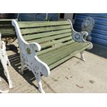 A PAIR OF WOOD SLAT GARDEN BENCHES WITH CAST IRON END SUPPORTS.
