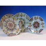 A PAIR AND ANOTHER SMALLER ENGLISH DELFT POLYCHROME PLATES, EACH WITH A CENTRAL SEVEN SIDED WHEEL