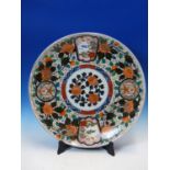 A JAPANESE IMARI DISH, THE ALTERNATING ROUNDELS AND FAN SHAPES ON A PEONY GROUND ENCLOSING THE