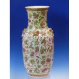 A CANTON VASE WITH FOUR GILT MASK AND RING HANDLES ON THE SHOULDERS AGAINST A GROUND OF FLOWERS,