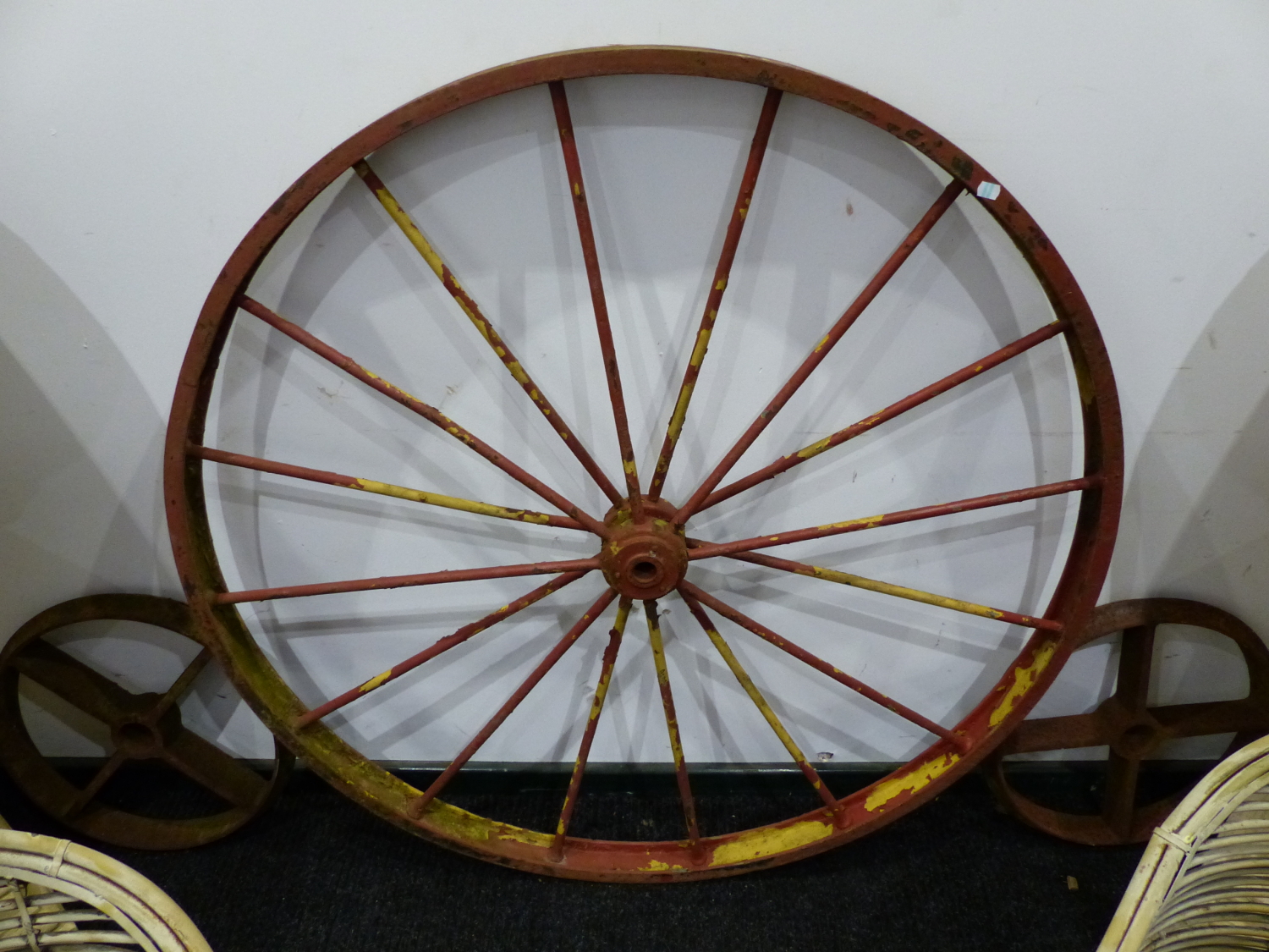 A PAIR OF LARGE IRON CARTWHEELS AND FOUR SMALLER IRON RAIL WHEELS.