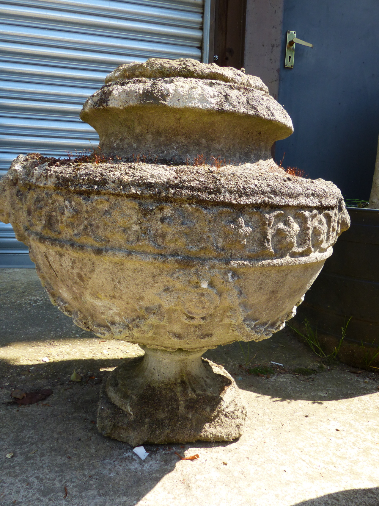 A SET OF FOUR CLASSICAL STYLE SWAG DECORATED COMPOSITE STONE GARDEN URNS, H 55cms.