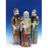 THREE FIGURES OF THE SHULUFU TRIAD, THEIR ROBES PAINTED IN FAMILLE ROSE ENAMELS, SHOULAO WITH