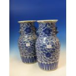 A PAIR OF CHINESE BLUE AND WHITE VASES, PAIRS OF BUDDHIST LION HANDLES BELOW THE CRIMPED RIMS, THE
