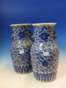 A PAIR OF CHINESE BLUE AND WHITE VASES, PAIRS OF BUDDHIST LION HANDLES BELOW THE CRIMPED RIMS, THE