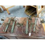 A SET OF FOUR WROUGHT IRON WALL MOUNTED TWO BRANCH CANDLE SCONCES. (4)