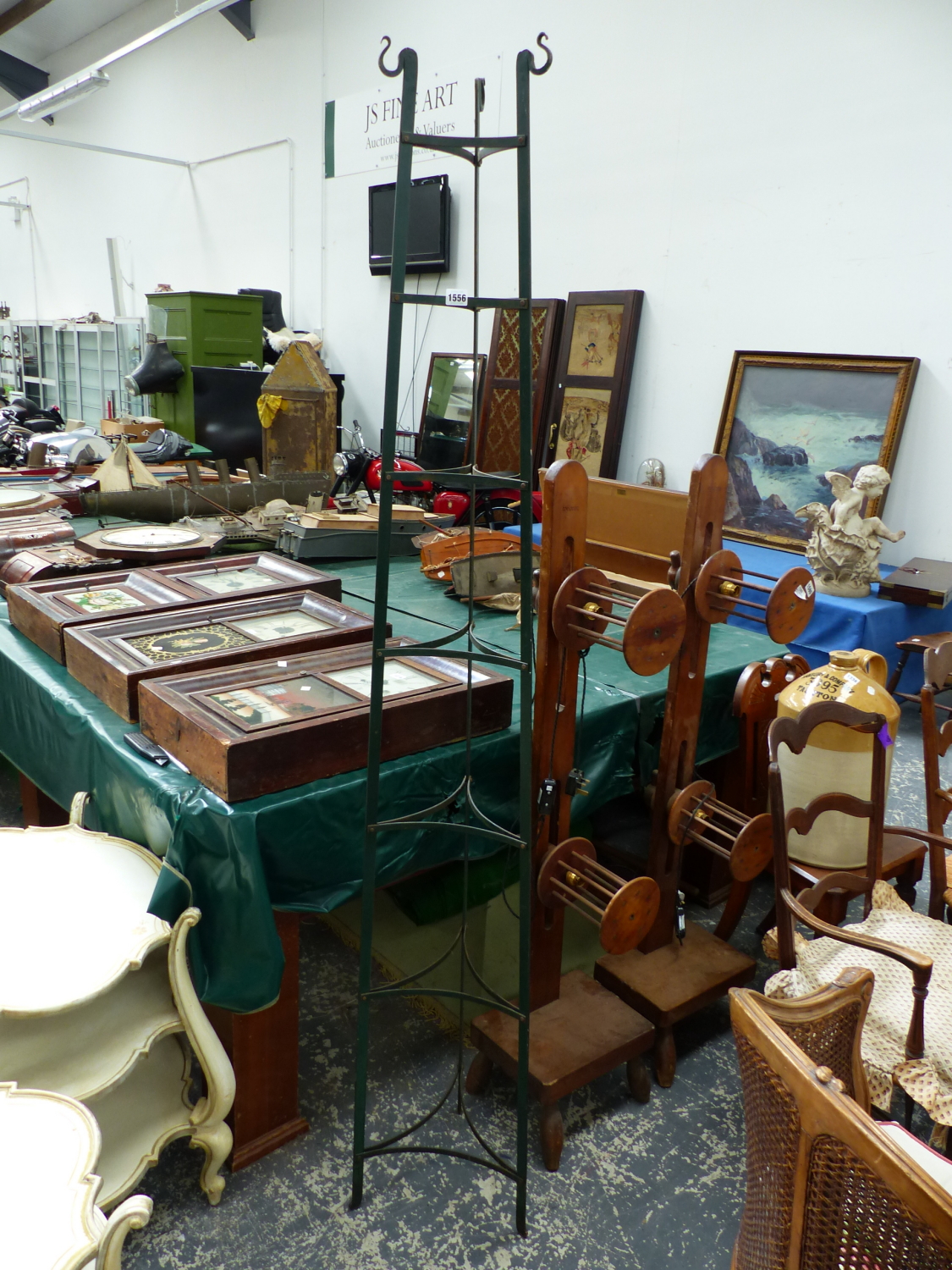 A GREEN PAINTED IRON SEVEN RACK POT STAND, THE THREE STRAPS SUPPORTING THE SHELVES TAPERING TO HOOKS