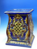 A BLUE GROUND POTTERY PLANTER STAND, THE SQUARE SECTIONED SIDES PIERCED WITH OCHRE GLAZED DIAMOND