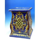 A BLUE GROUND POTTERY PLANTER STAND, THE SQUARE SECTIONED SIDES PIERCED WITH OCHRE GLAZED DIAMOND