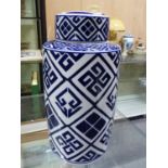 A BLUE AND WHITE CYLINDRICAL JAR AND COVER, THE PANELS OF THE DIAMOND DIAPERED SIDES FILLED WITH