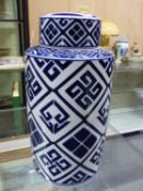A BLUE AND WHITE CYLINDRICAL JAR AND COVER, THE PANELS OF THE DIAMOND DIAPERED SIDES FILLED WITH