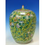 A CHINESE YELLOW GROUND OVOID JAR AND COVER PAINTED WITH CHILDREN AMONGST FRUITS AND ITS SCROLLING