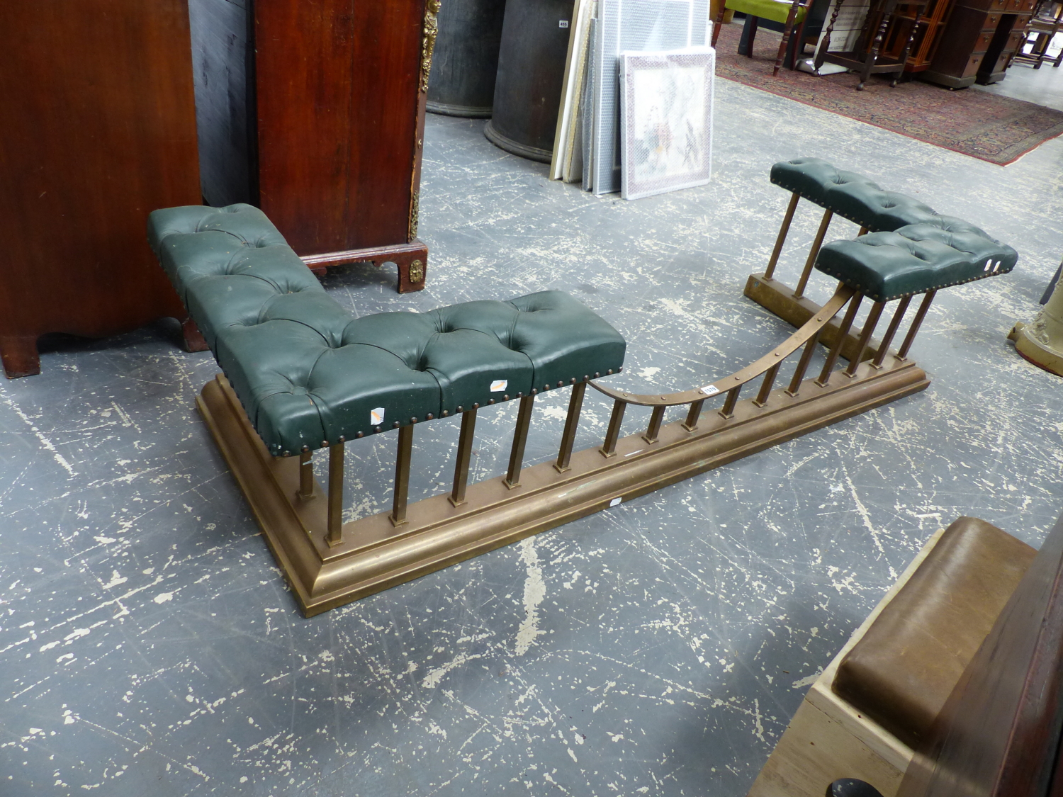 AN ANTIQUE BRASS AND LEATHER UPHOLSTERED CLUB FENDER. W.177 x D.63 x H.40cms.