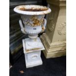A PAIR OF VICTORIAN STYLE SMALL CAST IRON URNS ON PEDESTAL BASES AND A PAIR OF ROCOCO STYLE IRON