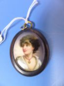 A GERMAN PORCELAIN OVAL PAINTED WITH A DARK HAIRED BOY WITH A MEDALLION AROUND HIS NECK, NOW MOUNTED