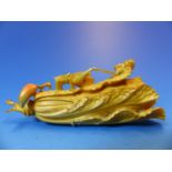 A JAPANESE TINTED IVORY CARVING OF A GRASS HOPPER ON A PAKCHOI WITH A CHILLI BY ITS STEM. W 11cms.