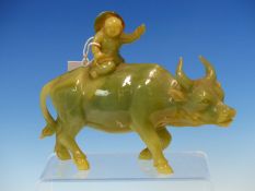 A CHINESE GREEN HARDSTONE WATER BUFFALO RIDDEN BY A BOY WITH A BROWN RIMMED HAT. W 19cms.