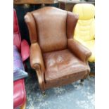 A LEATHER UPHOLSTERED WING BACK ARM CHAIR.