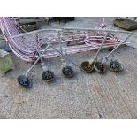 A SET OF SIX VINTAGE CAST IRON CATTLE FEEDERS.