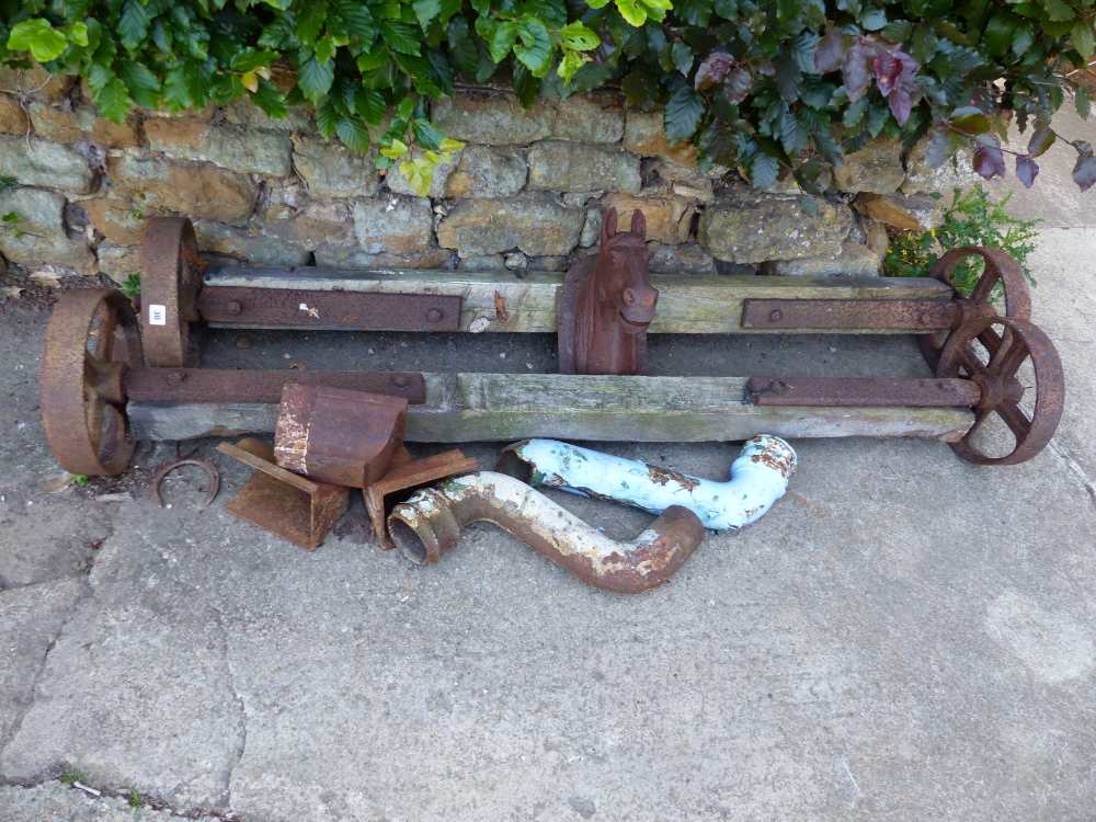 A PAIR OF VINTAGE AXLES, RAIN HOPPERS AND A WALL MOUNTED IRON HORSE HEAD.