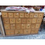 AN ANTIQUE PINE RUN OF 26 APOTHECARY OR SPICE DRAWERS TOGETHER WITH A GLAZED PINE CABINET.