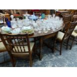 A LARGE OAK GATELEG DINING TABLE AND EIGHT SPINDLE BACK DINING CHAIRS.