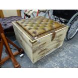 A LEATHER BUTTON UPHOLSTERED TOP BOX STOOL, WITH CAMPAIGN TYPE RECESSED HANDLES.