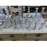 A COLLECTION OF SILVER PLATED CANDLESTICKS AND CANDELABRA.