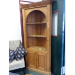 A PINE FLOOR STANDING CORNER CABINET.