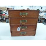 A FOUR DRAWER WOODED JEWELLERY CASE AND CONTENTS COMPRISING OF MAINLY COSTUME JEWELLERY.