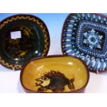 A COLLECTION OF SEVENTEEN 1970S HAMPTON POTTERY SLIP WARE DISHES VARIOUSLY DECORATED WITH STIPPLING,