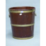 A 19th C. MAHOGANY PEAT BUCKET COOPERED WITH THREE BRASS BANDS AND WITH HANDLES TO EACH SIDE. Dia.