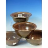 FOUR ABDO NAGI MAUVE GLAZED BOWLS WITH FLAT RIMS ON BODIES ROUNDING DOWN TO THE CIRCULAR FEET.