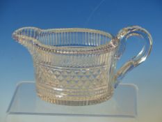 AN EARLY 19th C. CUT GLASS JUG, THE FACETTED INVERTED RIM ABOVE A BODY OF OVAL SECTION CUT WITH A