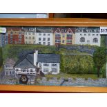TWO FRAMED DIORAMAS OF VILLAGE HARBOURS, THE LARGER FRAME. W 48 x H 23cms.