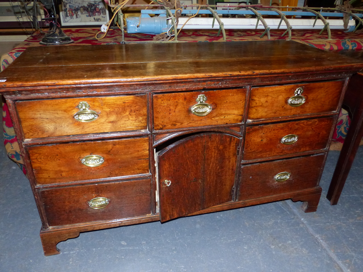 AN 18th C. OAK DRESSER BASE, A CENTRAL DRAWER AND ROUND ARCHED TOPPED CUPBOARD DOOR BELOW THE