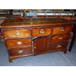 AN 18th C. OAK DRESSER BASE, A CENTRAL DRAWER AND ROUND ARCHED TOPPED CUPBOARD DOOR BELOW THE