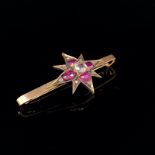 AN ANTIQUE VICTORIAN RUBY AND DIAMOND STAR BURST BAR BROOCH. LENGTH 5cms, STAR 3cms. WEIGHT 4.9grms.