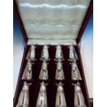 A CASED SET OF TWELVE SILVER PLATED FOX HEAD STIRRUP CUPS, EACH WITH TRUMPET SHAPED BOWL. H 14cms.