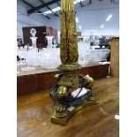 A GILT BRONZE COLUMNAR TABLE LAMP, THE REEDED COLUMN FLARING TO FOLIAGE CAST AT THE BASE SUPPORTED