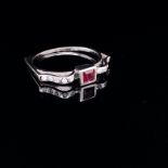 AN 18ct WHITE GOLD UNHALLMARKED RUBY AND DIAMOND RING. THE CENTRAL RUBY PRINCESS CUT IN A RUBOVER