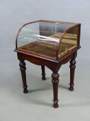 A 19th C. GLAZED MAHOGANY SHOP DISPLAY TABLE, THE FRONT ROUNDED ABOVE TURNED AND TAPERING