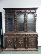 A VICTORIAN CARVED OAK LARGE GLAZED BOOKCASE, THREE GLAZED UPPER DOORS WITH FIGURAL PILLASTERS